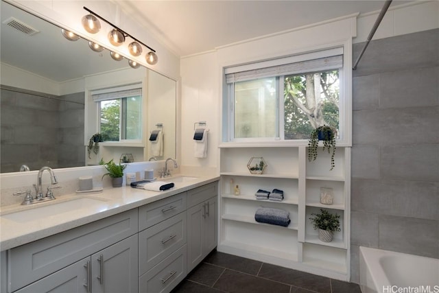 bathroom featuring tile patterned flooring, vanity, and tiled shower / bath combo