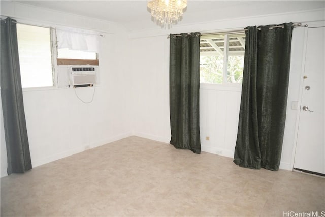 spare room with cooling unit and an inviting chandelier