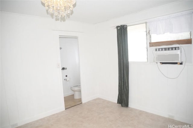 empty room featuring an inviting chandelier and a wall mounted air conditioner