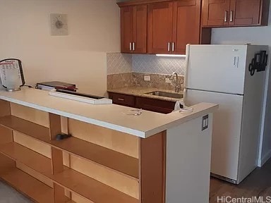 kitchen featuring sink, white fridge, and backsplash