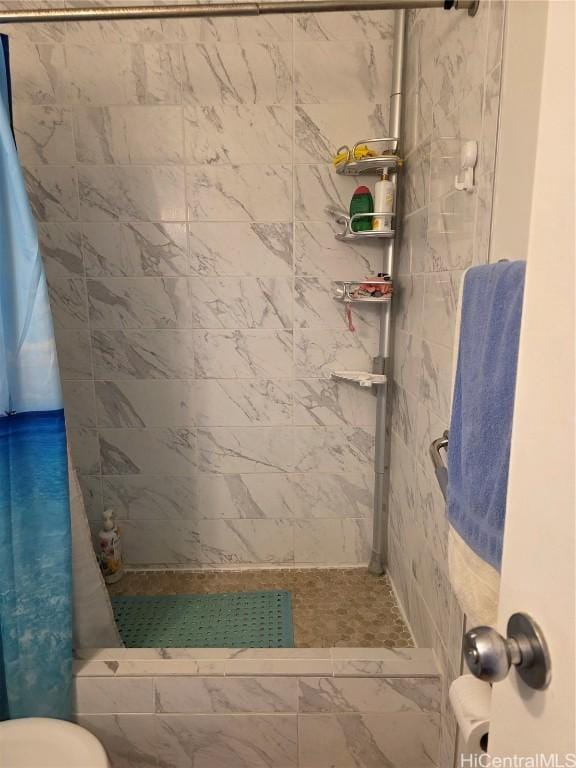 bathroom with a shower with curtain and toilet