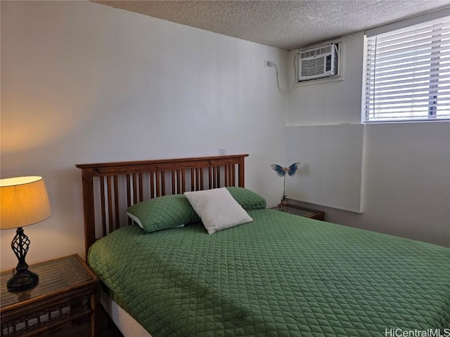 bedroom featuring a textured ceiling and a wall unit AC