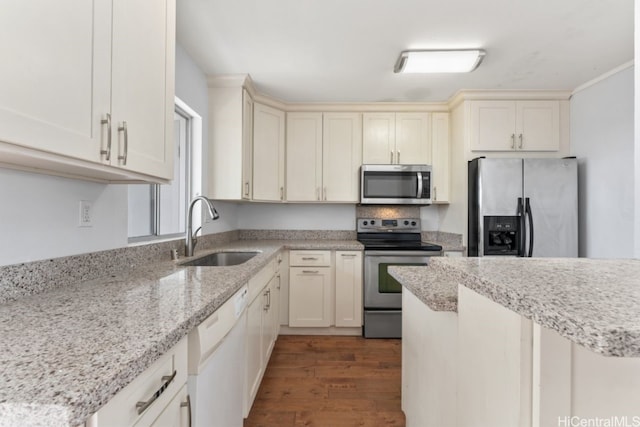 kitchen featuring appliances with stainless steel finishes, sink, light hardwood / wood-style flooring, light stone counters, and cream cabinetry