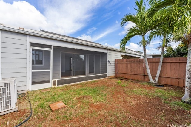 back of property featuring a yard, central AC, and a sunroom