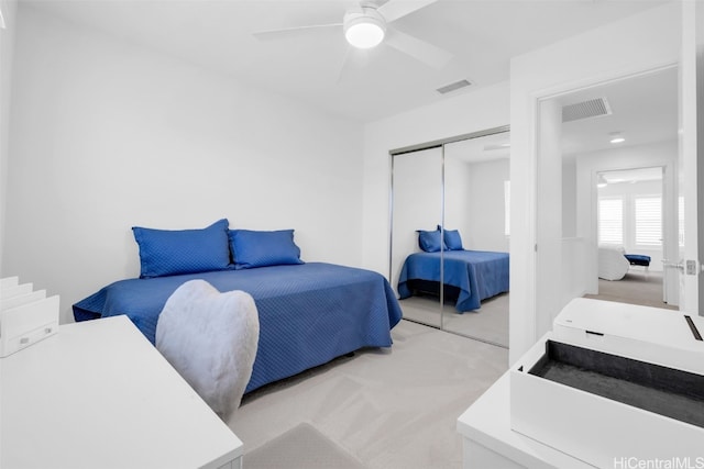 carpeted bedroom with ceiling fan and a closet