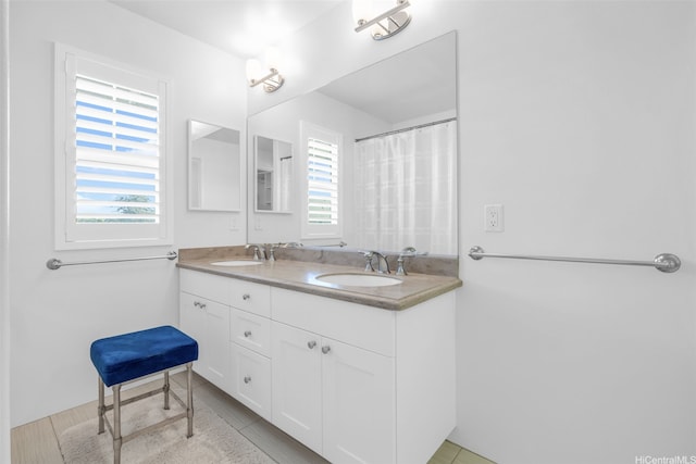 bathroom with a healthy amount of sunlight, a sink, and double vanity
