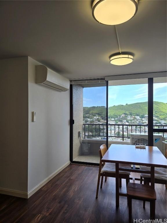 dining room featuring a mountain view, dark wood-type flooring, floor to ceiling windows, and a wall mounted AC