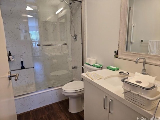 bathroom with hardwood / wood-style flooring, walk in shower, vanity, and toilet