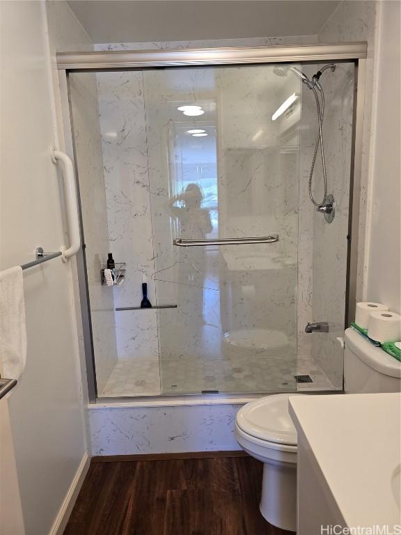 bathroom with vanity, toilet, a shower with shower door, and hardwood / wood-style floors