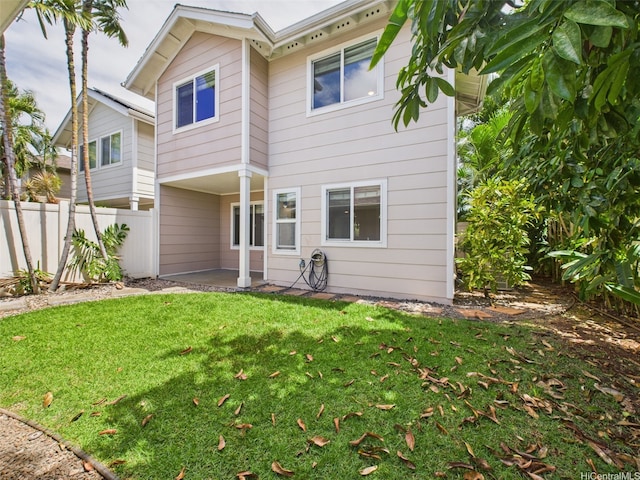 back of property featuring a yard, a patio area, and fence