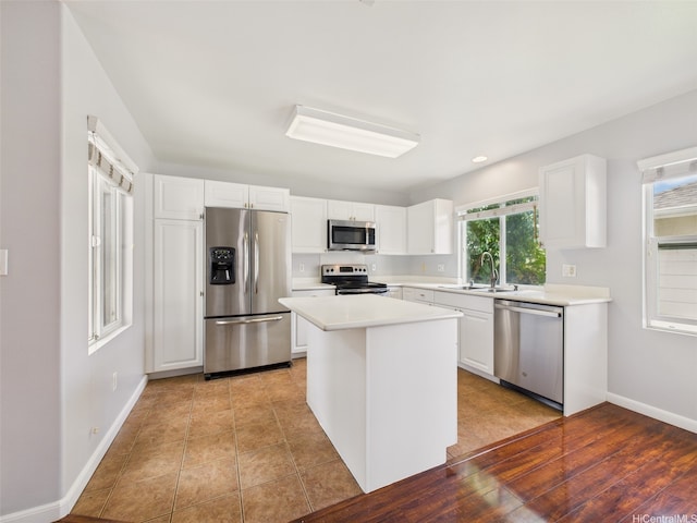 kitchen with stainless steel appliances, white cabinets, light countertops, and a sink