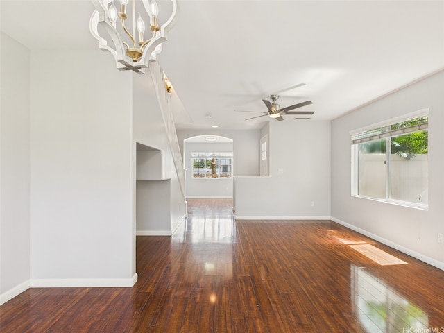 spare room featuring hardwood / wood-style floors, ceiling fan with notable chandelier, and baseboards