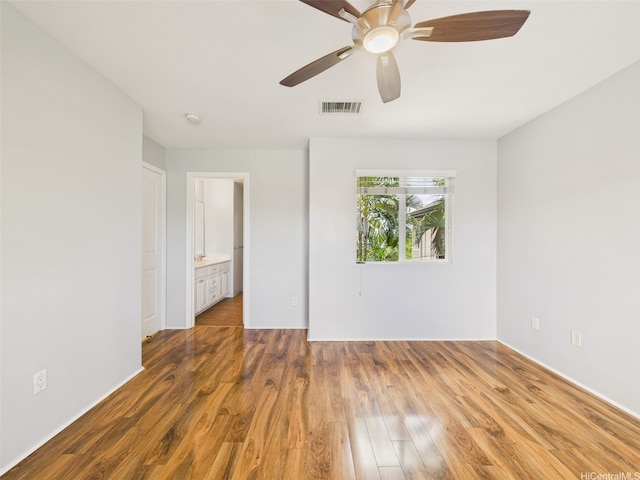 unfurnished room with visible vents, a ceiling fan, and wood finished floors