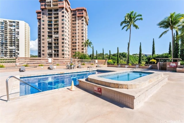 view of swimming pool featuring a patio, a hot tub, and fence