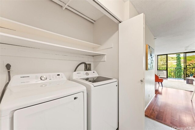 laundry area featuring washing machine and dryer, laundry area, and wood finished floors