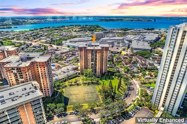 aerial view at dusk featuring a water view and a view of city