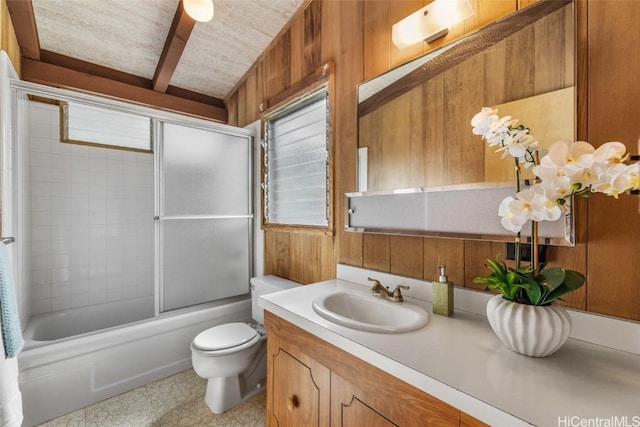 full bathroom with wood walls, enclosed tub / shower combo, vanity, toilet, and beam ceiling