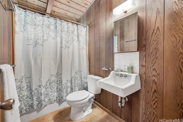 bathroom featuring wood ceiling, toilet, sink, and wood walls