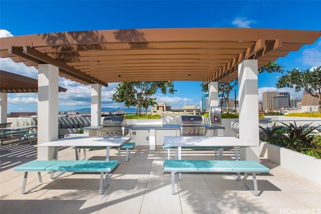 view of patio / terrace featuring exterior kitchen, grilling area, and a pergola