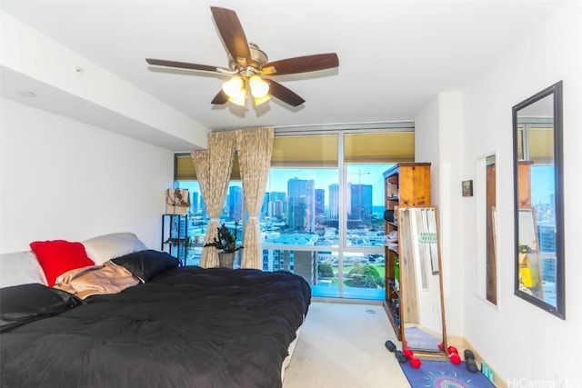 carpeted bedroom with a wall of windows and ceiling fan