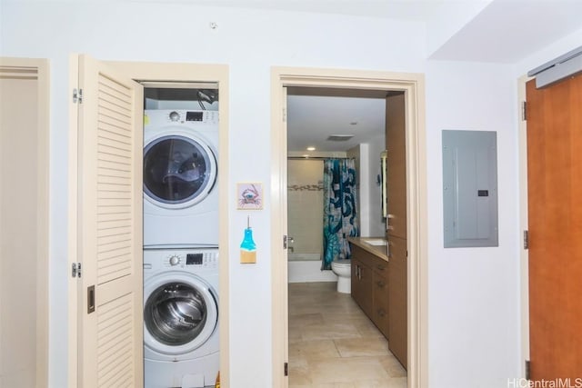 laundry area with stacked washer and dryer and electric panel