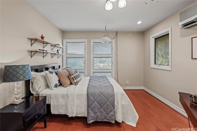 bedroom featuring a wall unit AC and wood-type flooring