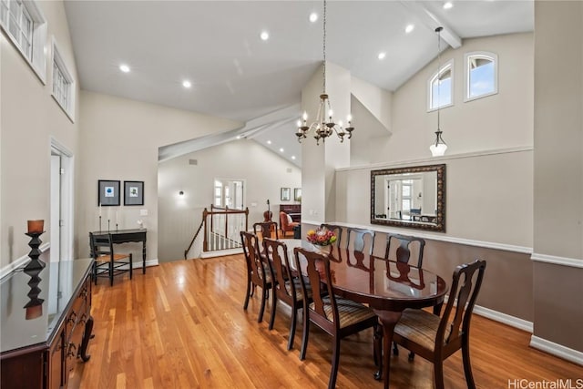 dining room featuring light wood-type flooring, high vaulted ceiling, a chandelier, and beam ceiling