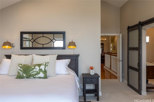 carpeted bedroom featuring a barn door and a chandelier