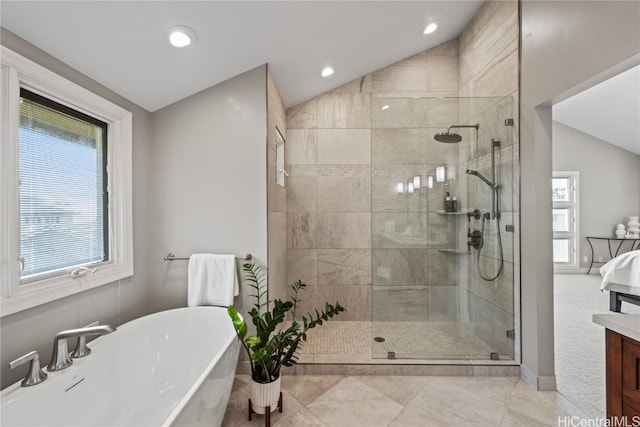 bathroom featuring vanity, shower with separate bathtub, and vaulted ceiling