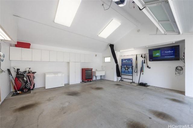 garage featuring refrigerator, sink, and a garage door opener