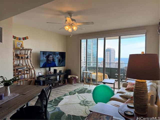 living room featuring ceiling fan and light hardwood / wood-style flooring