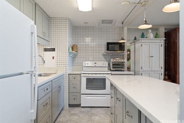 kitchen featuring sink, white appliances, gray cabinets, tasteful backsplash, and decorative light fixtures