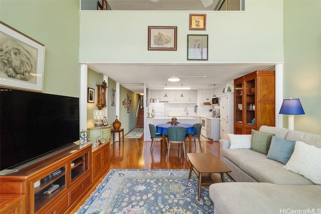 living room featuring a towering ceiling and wood-type flooring