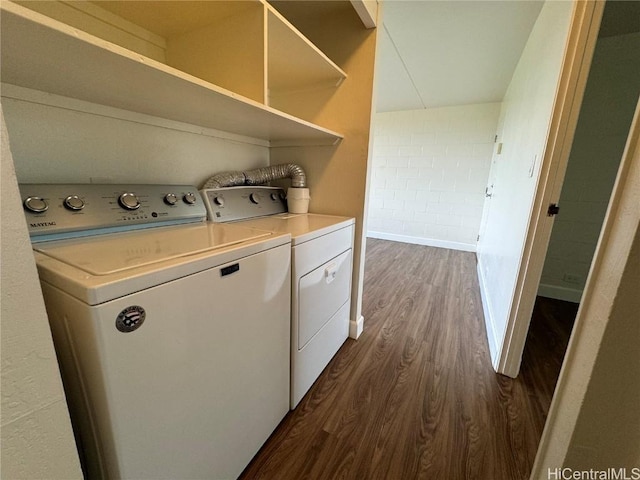 clothes washing area with dark wood-type flooring and washing machine and dryer