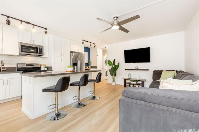 kitchen with a kitchen island, appliances with stainless steel finishes, a breakfast bar area, and white cabinets