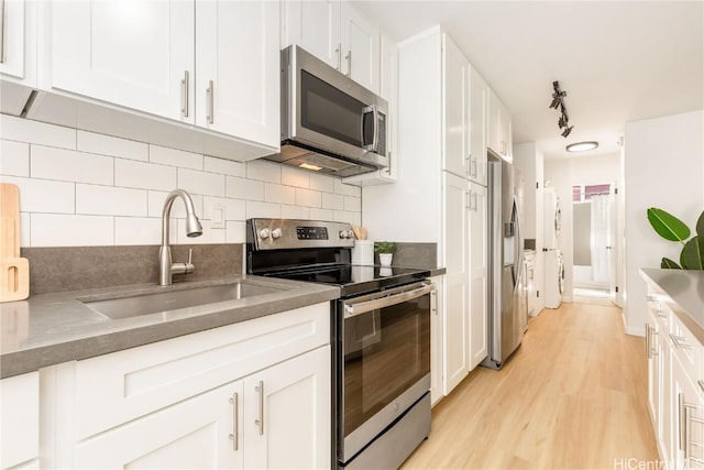 kitchen featuring appliances with stainless steel finishes, sink, decorative backsplash, and white cabinets