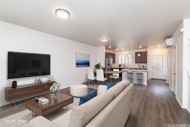 living room featuring sink, wood-type flooring, and a wall mounted AC