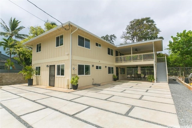 rear view of house featuring ceiling fan, a balcony, and a patio area