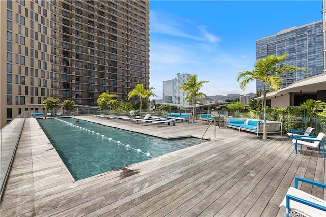 community pool with a city view and a wooden deck