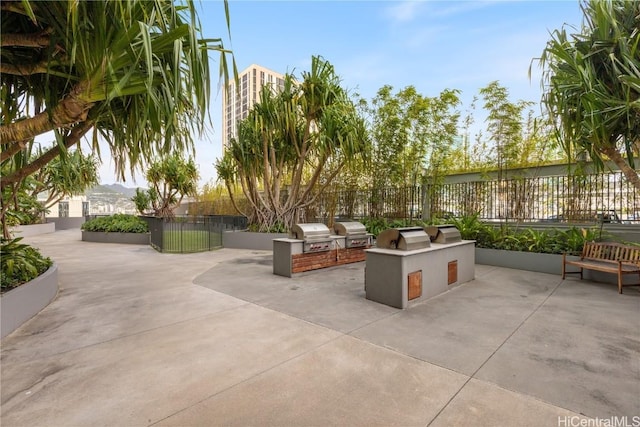 view of patio / terrace with exterior kitchen, a grill, and fence