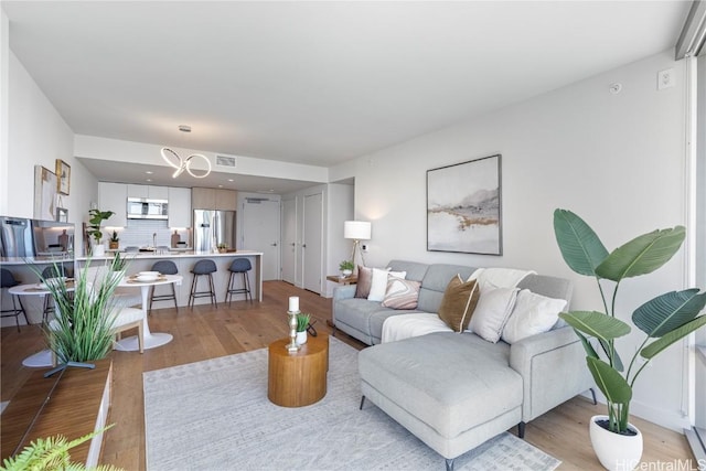 living area with visible vents and light wood-style flooring