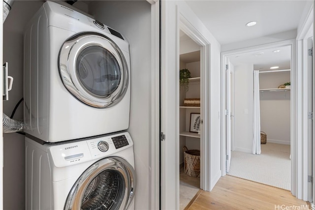 laundry room featuring stacked washer and dryer, light wood finished floors, laundry area, and recessed lighting