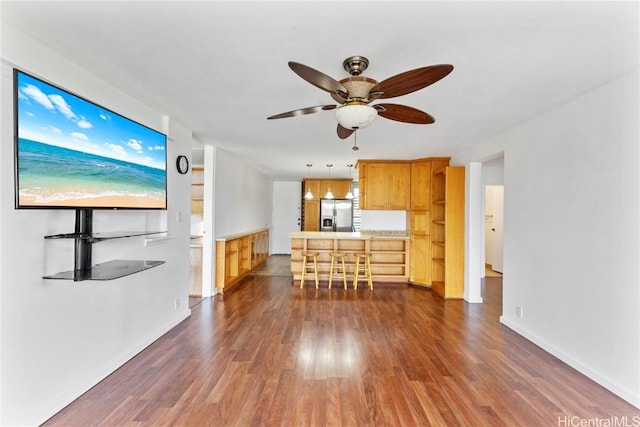 unfurnished living room with dark wood-style floors and a ceiling fan