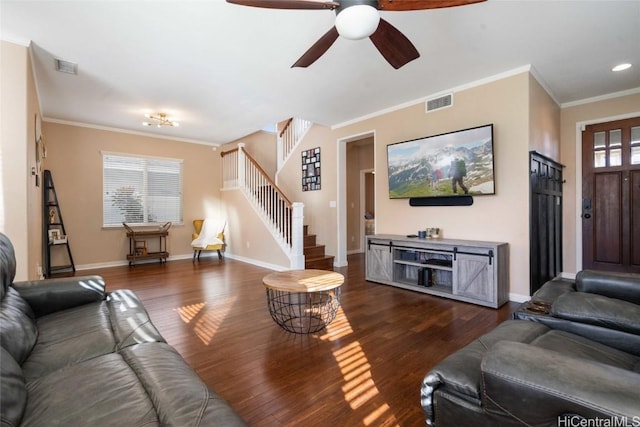 living room with ornamental molding, wood finished floors, baseboards, and stairs