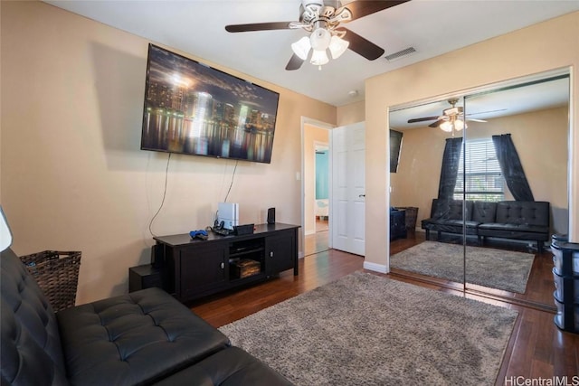 living area with wood finished floors, visible vents, and baseboards