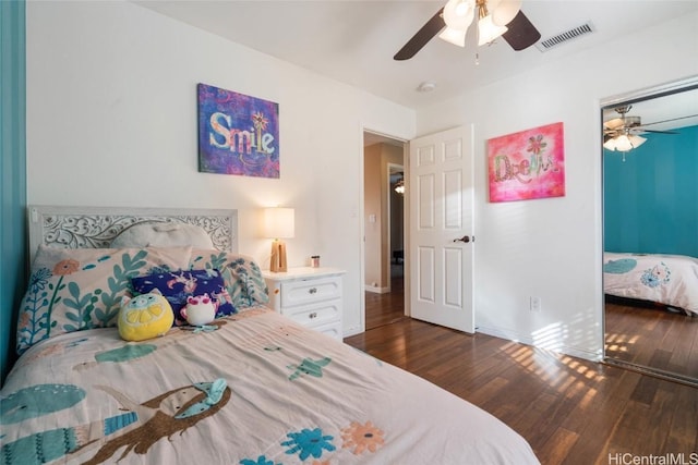 bedroom with ceiling fan, dark wood finished floors, visible vents, and baseboards