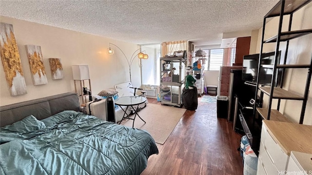 bedroom with a textured ceiling and wood finished floors