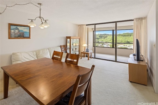 dining room featuring a wall of windows, light colored carpet, a notable chandelier, and a textured ceiling