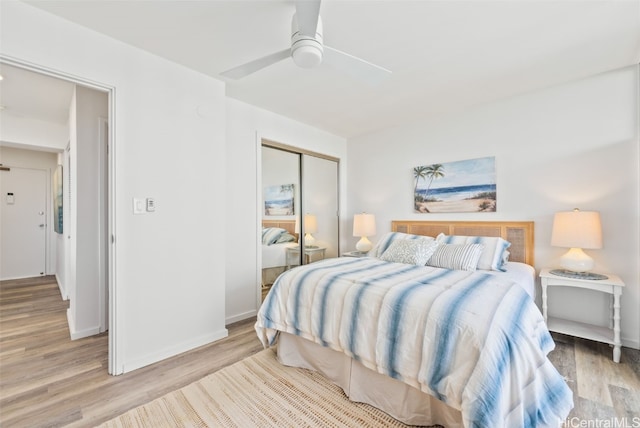 bedroom with light wood finished floors, a closet, a ceiling fan, and baseboards