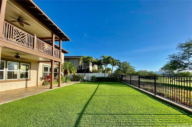 view of yard featuring ceiling fan, a balcony, and a patio